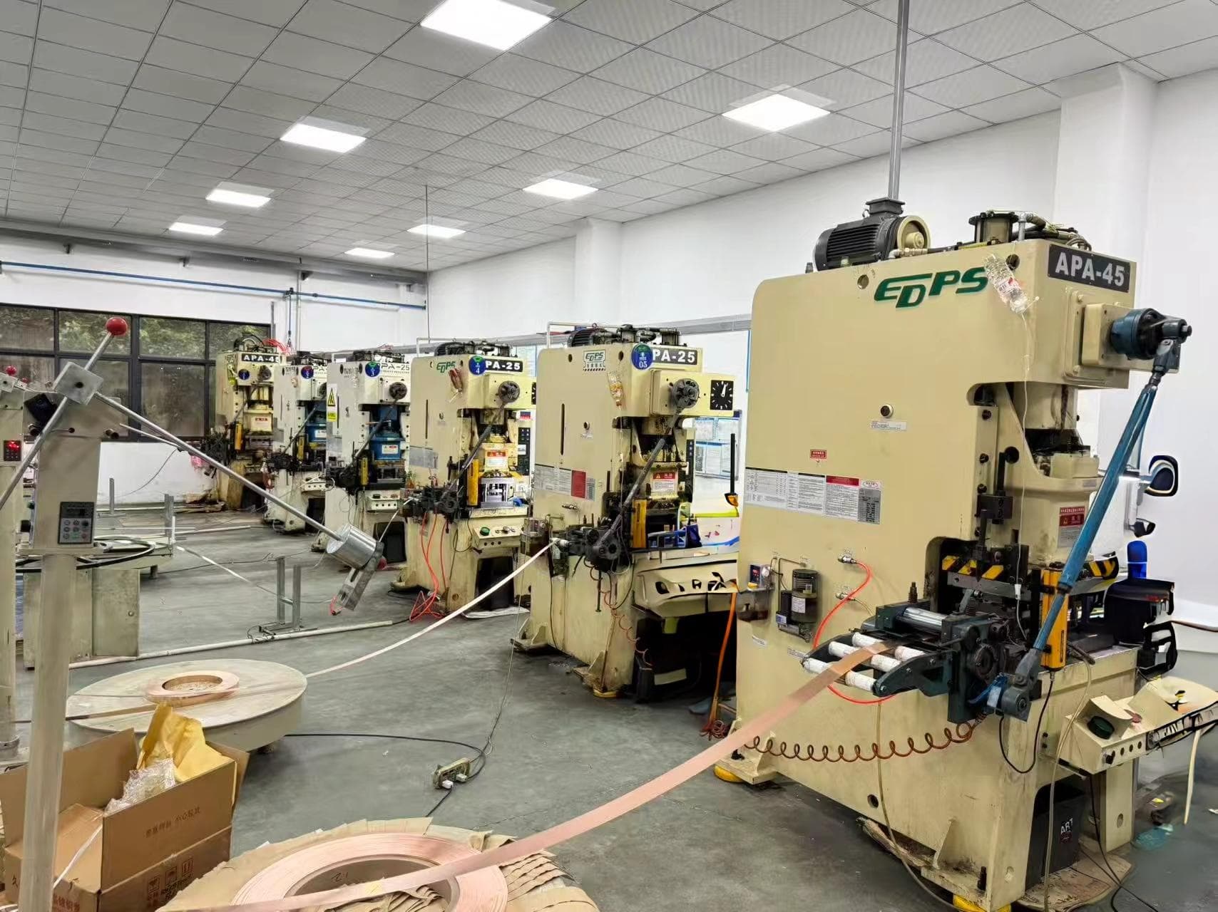 Row of automatic stamping presses feeding copper strip